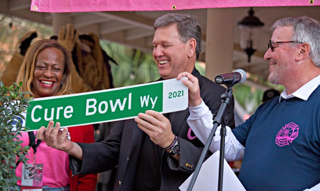 men and woman holding cure bowl sign